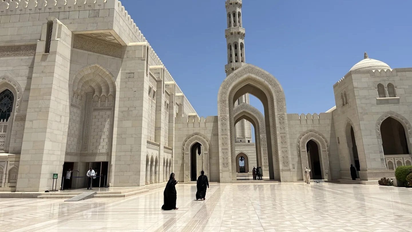 mosque and women wearing black butterfly abaya